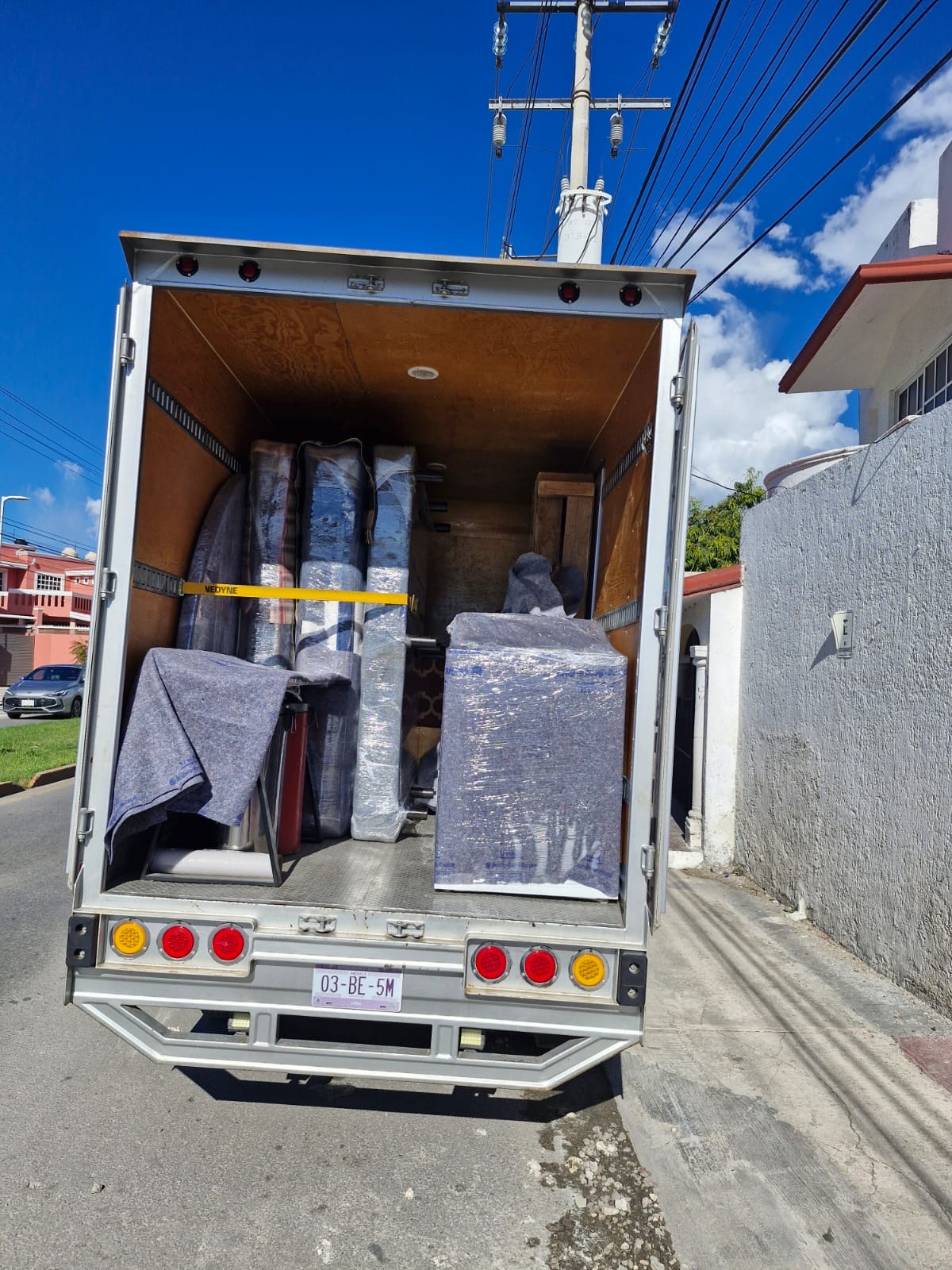 Muebles emplayados y protegidos con mantas dentro de la caja del vehículo